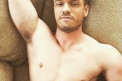 Kyle-Mason-posing-on-a-couch-shirtless